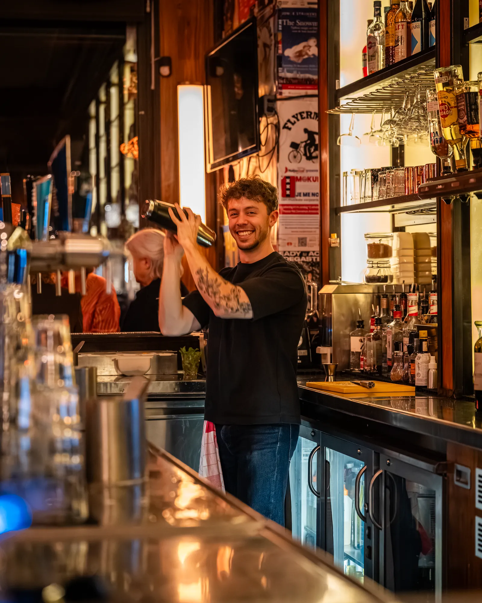 Barman schudt een cocktailshaker achter de bar