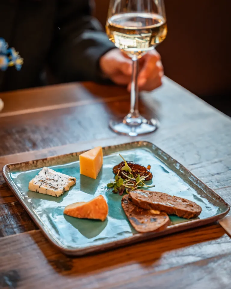 Kaasplankje op tafel met een glas witte wijn